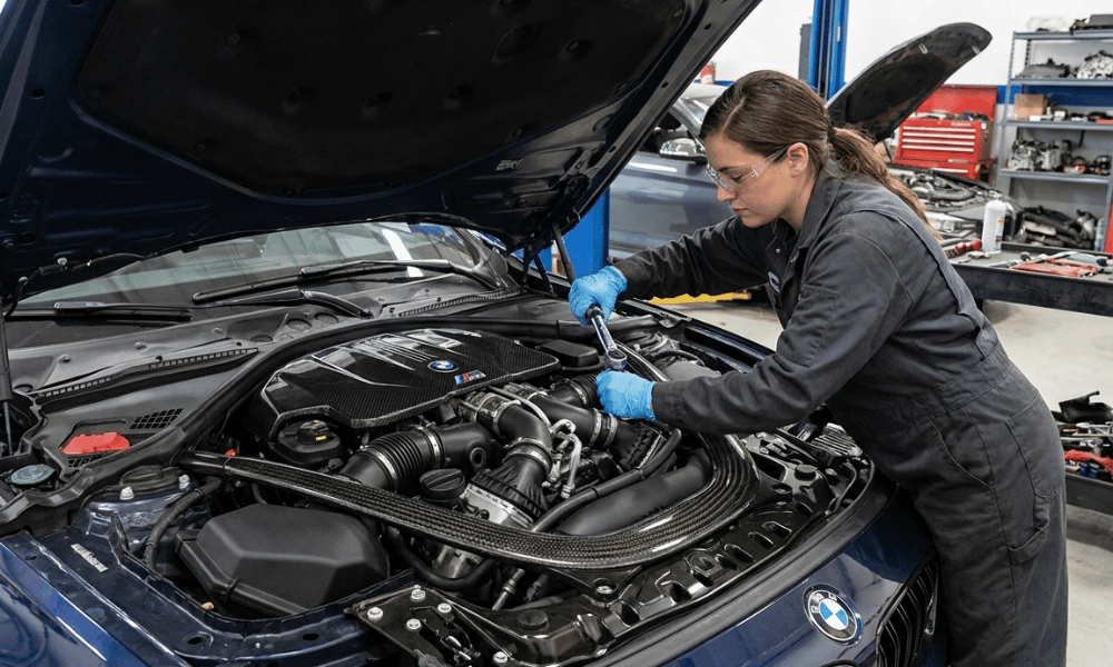 Female technician performing repairs on a BMW